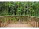 Outdoor wooden deck overlooking a lush green forest, creating a serene and private outdoor space at 4095 Oriole Ln, Fairburn, GA 30213