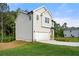 Side view of a two-story home with light siding, a two-car garage, and a green lawn at 4095 Oriole Ln, Fairburn, GA 30213
