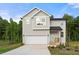 Charming two-story home with a two-car garage, light siding, and landscaped front yard at 4095 Oriole Ln, Fairburn, GA 30213