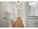 Hallway with hardwood floors, leading to the front door and a half bath with a granite countertop at 4095 Oriole Ln, Fairburn, GA 30213