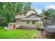 Backyard of a two-story home with a deck and a grassy lawn at 574 Hickory Hills Ct, Stone Mountain, GA 30083
