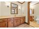 Bathroom with marble countertops, wood cabinets, framed mirror, sconces, and toilet at 574 Hickory Hills Ct, Stone Mountain, GA 30083