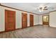 Spacious bedroom features neutral walls, hardwood trim, ceiling fan, and multiple closet doors at 574 Hickory Hills Ct, Stone Mountain, GA 30083