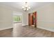 A dining room featuring a modern light fixture and an open view to the living room through a large doorway at 574 Hickory Hills Ct, Stone Mountain, GA 30083