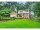 Beautifully landscaped front yard with lush green grass enhancing this lovely two-story brick house at 574 Hickory Hills Ct, Stone Mountain, GA 30083