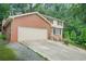 Charming two-story brick home featuring an attached two-car garage and a well-manicured lawn at 574 Hickory Hills Ct, Stone Mountain, GA 30083