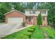 Charming two-story brick home featuring a well-manicured lawn and inviting front porch at 574 Hickory Hills Ct, Stone Mountain, GA 30083