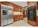 Spacious kitchen featuring stainless steel refrigerator, oven, and wood cabinets with granite countertops at 574 Hickory Hills Ct, Stone Mountain, GA 30083