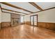 A well-lit living room with a brick fireplace, wood floors, and beamed ceiling at 574 Hickory Hills Ct, Stone Mountain, GA 30083
