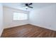 Bright bedroom featuring wood floors, a ceiling fan, white trim, and a large window with natural light at 115 Biscayne Nw Dr # F10, Atlanta, GA 30309