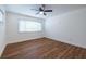 Bright bedroom featuring wood floors, a ceiling fan, white trim, and a large window with natural light at 115 Biscayne Nw Dr # F10, Atlanta, GA 30309
