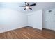 Bright bedroom with wood floors, a ceiling fan, and a closet and door with white trim at 115 Biscayne Nw Dr # F10, Atlanta, GA 30309