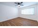 Bright bedroom featuring wood floors, a ceiling fan, white trim, and a large window with natural light at 115 Biscayne Nw Dr # F10, Atlanta, GA 30309