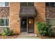 Apartment building entrance featuring a dark awning, stone and brick accents, and neat landscaping at 115 Biscayne Nw Dr # F10, Atlanta, GA 30309