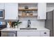 Modern kitchen features stainless steel appliances, a stylish faucet, and floating shelves at 115 Biscayne Nw Dr # F10, Atlanta, GA 30309