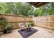 A cozy patio is adorned with comfortable seating, a small table, and potted plants, enclosed by a wood fence at 115 Biscayne Nw Dr # F10, Atlanta, GA 30309