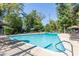A large, clear blue swimming pool is surrounded by lush greenery, lounge chairs, and patio umbrellas at 115 Biscayne Nw Dr # F10, Atlanta, GA 30309