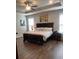 Spacious main bedroom featuring a tray ceiling, hardwood floors, and a luxurious king-sized bed at 2159 Holland Creek Ln, Buford, GA 30519