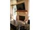 Outdoor brick fireplace with a mounted TV and festive décor, creating a cozy ambiance at 2159 Holland Creek Ln, Buford, GA 30519