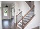 Traditional foyer boasts staircase with iron spindles and natural wood banister, chandelier, and front door at 2159 Holland Creek Ln, Buford, GA 30519