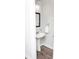 Bright powder room featuring a pedestal sink and a framed mirror at 2159 Holland Creek Ln, Buford, GA 30519