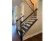 Staircase with wooden steps and black iron railing that leads to the upper level at 2159 Holland Creek Ln, Buford, GA 30519