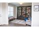 Study boasts dark grey floor-to-ceiling bookcase with library ladder and a patterned rug at 2159 Holland Creek Ln, Buford, GA 30519