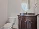 Powder room featuring vanity, granite countertop, decorative mirror, and toilet at 3487 Binghurst Rd, Suwanee, GA 30024
