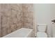 Bathroom features tiled tub, large vanity with a toilet, and tiled walls at 3487 Binghurst Rd, Suwanee, GA 30024