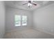 This bedroom features neutral walls, carpet, tray ceiling with fan and a large window for natural light at 3487 Binghurst Rd, Suwanee, GA 30024