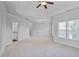 Large bedroom featuring neutral carpet, ceiling fan, and multiple bright windows at 3487 Binghurst Rd, Suwanee, GA 30024