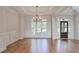 Dining space featuring wood floors, wainscoting, and a dark wood entry door at 3487 Binghurst Rd, Suwanee, GA 30024