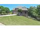 Traditional brick home with a manicured lawn, mature trees and a three-car garage at 3487 Binghurst Rd, Suwanee, GA 30024