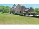 Charming brick home featuring lush green lawn and manicured shrubbery in front yard at 3487 Binghurst Rd, Suwanee, GA 30024