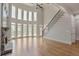 Open living room with fireplace, large windows, and a staircase at 3487 Binghurst Rd, Suwanee, GA 30024