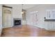 Bright living room featuring a fireplace, built-in cabinets, wood floors, and access to the outdoors at 3487 Binghurst Rd, Suwanee, GA 30024