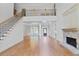 Open living space with stone fireplace, second-story overlook, and hardwood floors at 3487 Binghurst Rd, Suwanee, GA 30024