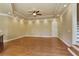 Open floor plan with wood floors, tray ceiling, recessed lights, and access to stairwell at 3487 Binghurst Rd, Suwanee, GA 30024