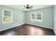 Bedroom with light blue walls, hardwood floors, natural light from two windows and ceiling fan at 3551 Clay Rd, Austell, GA 30106