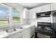 Well-lit kitchen with white cabinets, stainless steel sink, stone backsplash, and modern appliances at 3551 Clay Rd, Austell, GA 30106