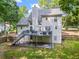 Backyard view of a home featuring a deck and a spacious yard surrounded by mature trees at 6065 Ashbury Ln, Cumming, GA 30028