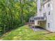 Exterior rear view of a home with a deck overlooking a grassy, wooded lot at 6065 Ashbury Ln, Cumming, GA 30028