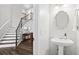Bathroom with white pedestal sink and staircase leading to the next level at 6065 Ashbury Ln, Cumming, GA 30028