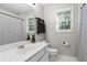 Bright bathroom with white vanity, neutral walls, and a window for natural light at 6065 Ashbury Ln, Cumming, GA 30028