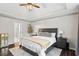 Cozy bedroom featuring a dark wood frame bed, side tables, and a window for natural light at 6065 Ashbury Ln, Cumming, GA 30028