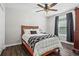 Well-lit bedroom featuring wood-look floors, a ceiling fan, and a bed with black and white bedding at 6065 Ashbury Ln, Cumming, GA 30028