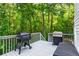 Spacious deck featuring a grill, smoker, and outdoor seating surrounded by lush trees at 6065 Ashbury Ln, Cumming, GA 30028