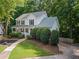 Charming two-story home exterior with manicured lawn, mature trees, and a paved driveway for easy parking at 6065 Ashbury Ln, Cumming, GA 30028