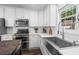 Bright kitchen showcases a stainless steel sink, white cabinets, and modern appliances at 6065 Ashbury Ln, Cumming, GA 30028