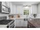 Modern kitchen equipped with stainless steel appliances, white cabinets, and stylish countertops at 6065 Ashbury Ln, Cumming, GA 30028